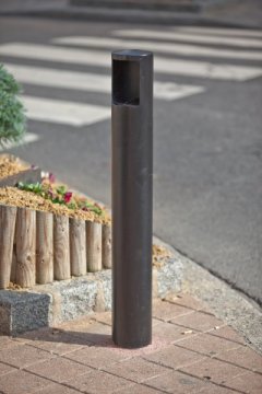 Vue d'un cendrier présent dans une rue passante.