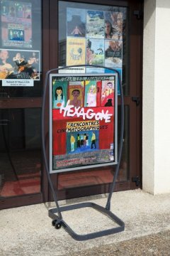 Affiche de film dans un porte-affiches de trottoir.