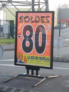 Affichage publicitaire sur les soldes en cours chez un commerçant de matelas.