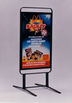 Un porte-affiches noir sur pied avec des ressorts figurant une publicité pour les restaurants McDonald's